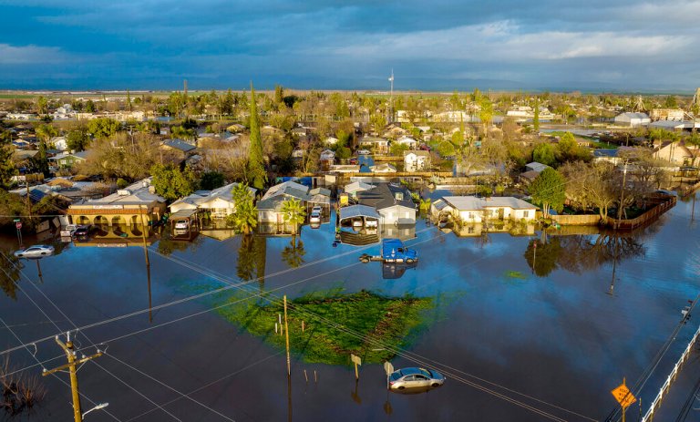 Following days of rain, levees overflowed and floodwaters surround homes and vehicles in the Planada community of Merced County, Calif., on Jan. 10, 2023. (AP Photo/Noah Berger)