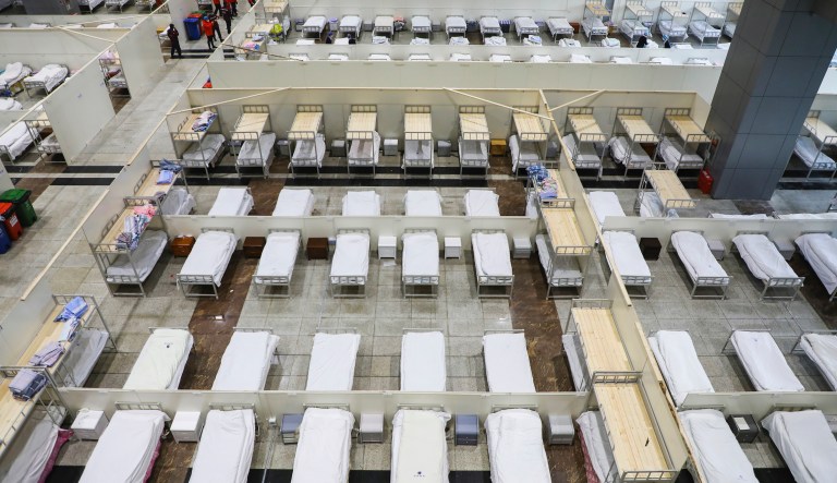 In this Wednesday, Feb. 5, 2020, photo, medical staff prepare beds at a temporary hospital which transformed from an exhibition center for accepting patients who diagnosed with the coronaviruses in Wuhan in central China's Hubei province. Ten more people were sickened with a new virus aboard one of two quarantined cruise ships with some 5,400 passengers and crew aboard, health officials in Japan said Thursday, as China reported 73 more deaths and announced that the first group of patients were expected to start taking a new antiviral drug.