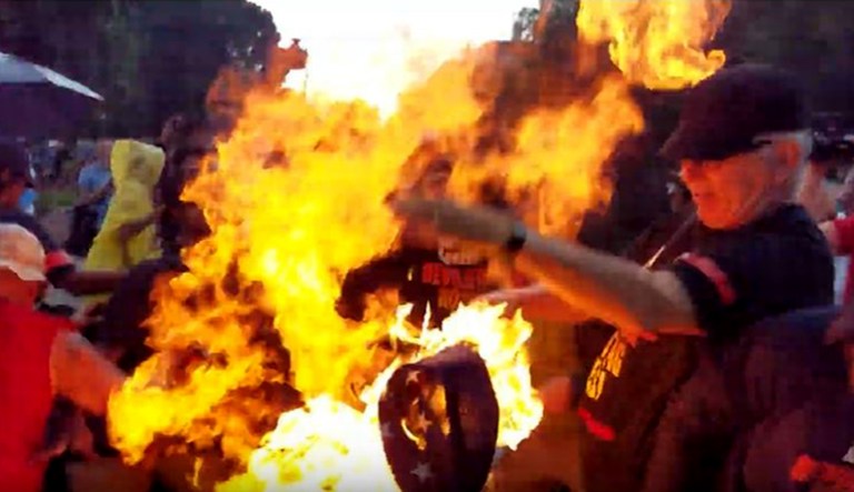 A person burns an American flag in front of the White House in Washington on July 4, 2019.