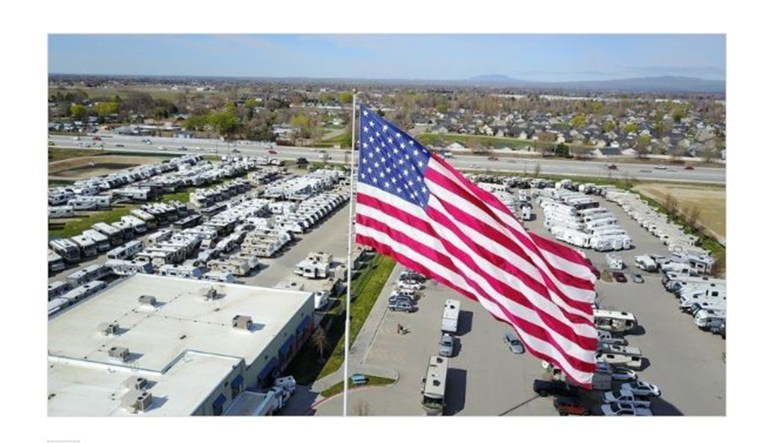 A large U.S. flag flies outside of a business.