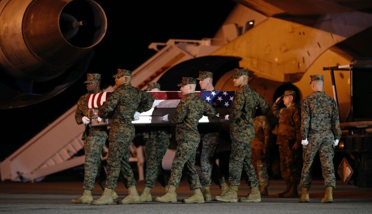 A U.S. Marine Corps carry team moves a transfer case containing the remains of Staff Sgt. Christopher A. Slutman, Thursday, April 11, 2019, at Dover Air Force Base, Del.