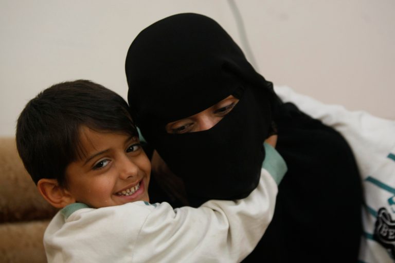 In this photo taken on Friday, Feb. 14, 2014, Hamza, 6, left, hugs his mother Abeer al-Hassani whose two brother were killed in a US drone strike last year and a third brother was killed in fighting against government troops in 2012. All three brothers had joined al-Qaida in Yemen before their deaths. (AP Photo/Hani Mohammed)