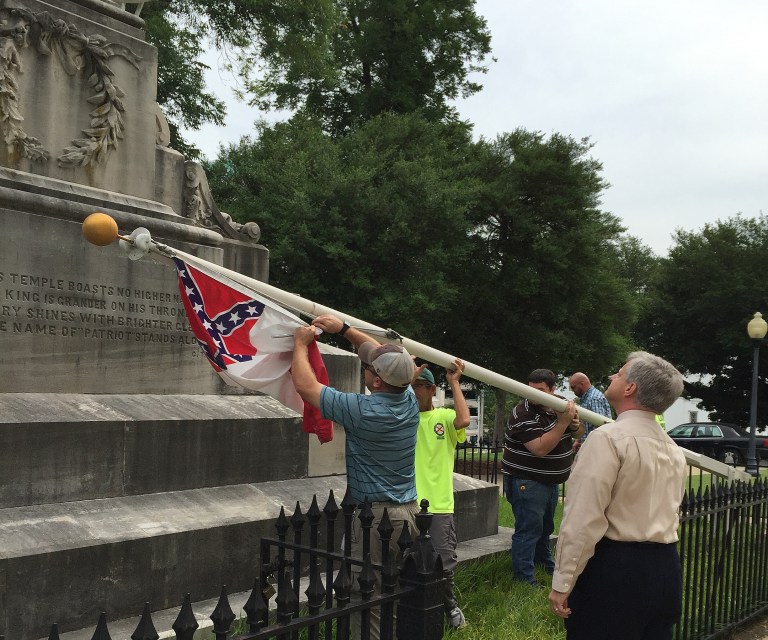 State workers take down a Confederate national flag on the grounds of the state Capitol, Wednesday, June 24, 2015, in Montgomery, Ala. Alabama Gov. Robert Bentley ordered Confederate flags taken down from a monument at the state Capitol. (AP Photo/Martin Swant)