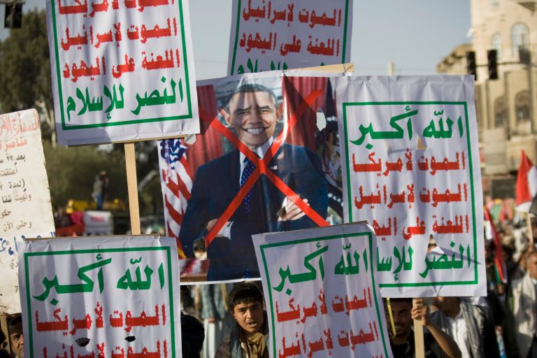 Houthi Shiite Yemenis hold a poster of U.S. President Barack Obama and banners in Arabic that read,