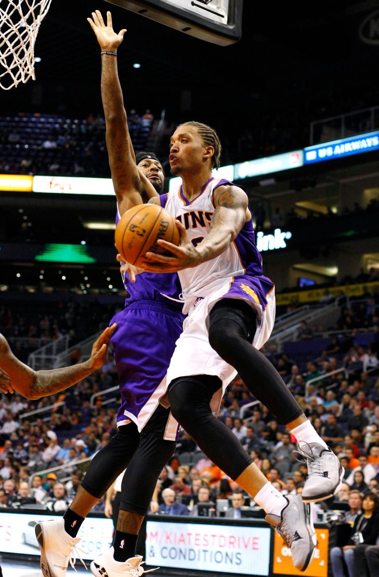   Phoenix Suns forward Michael Beasley (0) drives past Sacramento Kings forward James Johnson (52) during the third quarter of an NBA basketball game, Monday, Dec. 17, 2012, in Phoenix. The Suns won 101-90. (AP Photo/Rick Scuteri)  