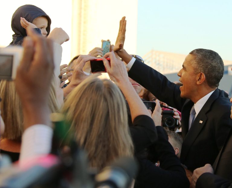 President Barack Obama exchanges high fives with a youngster after arriving at Love Field in Dallas on Wednesday. Obama came to Texas to promote his health care law. (AP Photo/The Dallas Morning News, Louis DeLuca) 