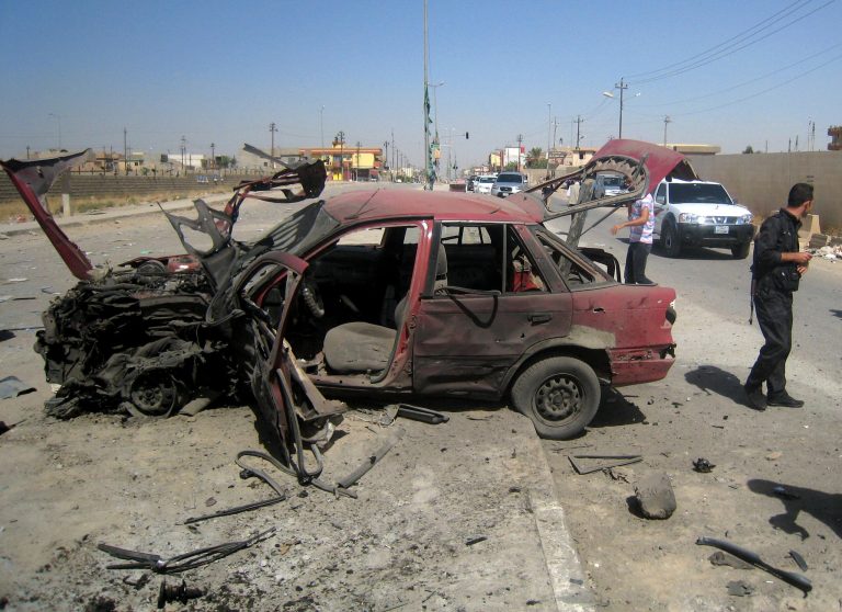 People inspect the site of a car bomb attack on cars lined up at a gas station in the oil rich city of Kirkuk, in northern Iraq, Thursday, July 10, 2014. The lightning sweep by the militants over much of northern and western Iraq the past month has dramatically hiked tensions between the country's Shiite majority and Sunni minority. At the same time, splits have grown between the Shiite-led government in Baghdad and the Kurdish autonomous region in the north.(AP Photo)