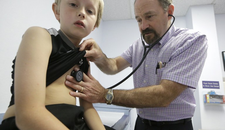 In this 2015 photo, Dr. John Porter examines Connor Russell, 8, during an office visit in Richardson, Texas. The National Governors Association released a Thursday statement warning about Children's Health Insurance Program funds just a few hours before the House is expected to consider a short-term continuing resolution that funds the government until Jan. 19 and includes $2.5 billion in stopgap funding for CHIP, which would expire at the end of March. (AP Photo/LM Otero)