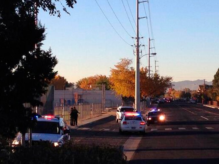 In this photo provided by Jerry Davis, police gather near Sparks Middle School after a shooting at the school, Monday, Oct. 21, 2013, in Reno, Nev. A student at the school opened fire on campus, killing a staff member who was trying to protect other children, police said Monday. The suspected gunman is also dead, and authorities say no shots were fired by law enforcement. (AP Photo/Jerry Davis)