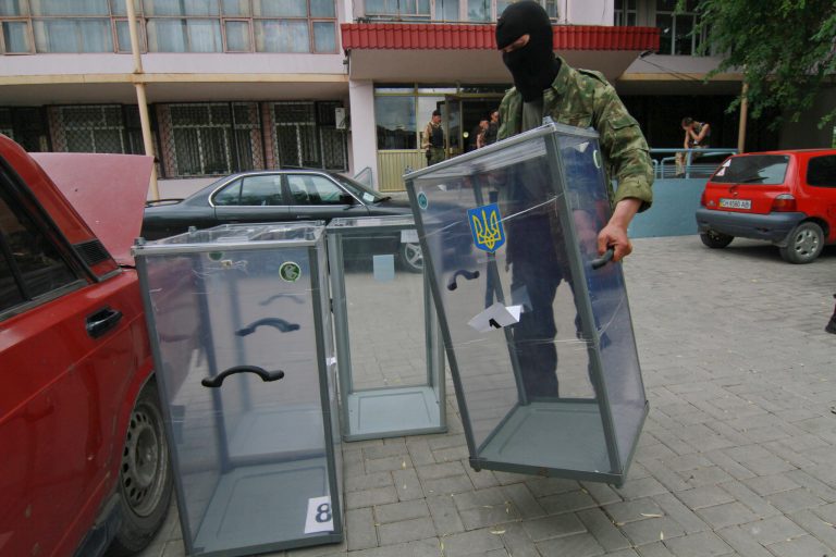 A Pro-Russian activist carries a ballot box away from a polling station preparing to smash it, in Donetsk, Ukraine, Friday, May 23, 2014. Ukraine's acting government has admitted that authorities will not be able to organize the voting in parts of eastern Ukraine, overrun by pro-Russian insurgents. (AP Photo/Photomig)