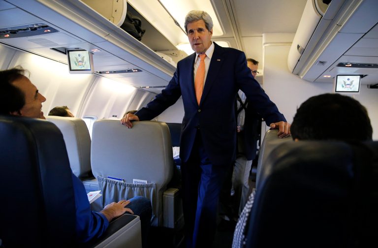 Secretary of State John Kerry greets media representatives flying aboard his plane bound for diplomatic talks in China while flying from Andrews Air Force Base, Md., Monday, July 7, 2014. Kerry is heading to Beijing to participate in the sixth round of the U.S.-China Strategic and Economic Dialogue. (AP Photo/Jim Bourg, Pool)