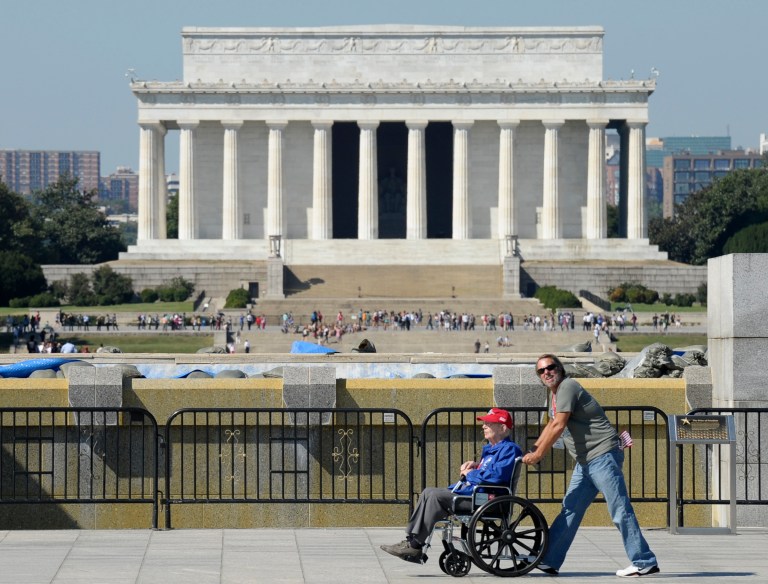   World War II veterans visit the World War II Memorial in Washington, Wednesday, Oct. 2, 2013. It was an act of civil disobedience that marked the fact some barriers nor a government shutdown would keep a group of World War II veterans from visiting the monument erected in their honor. The Lincoln Memorial is in the background. (AP Photo/Susan Walsh)  