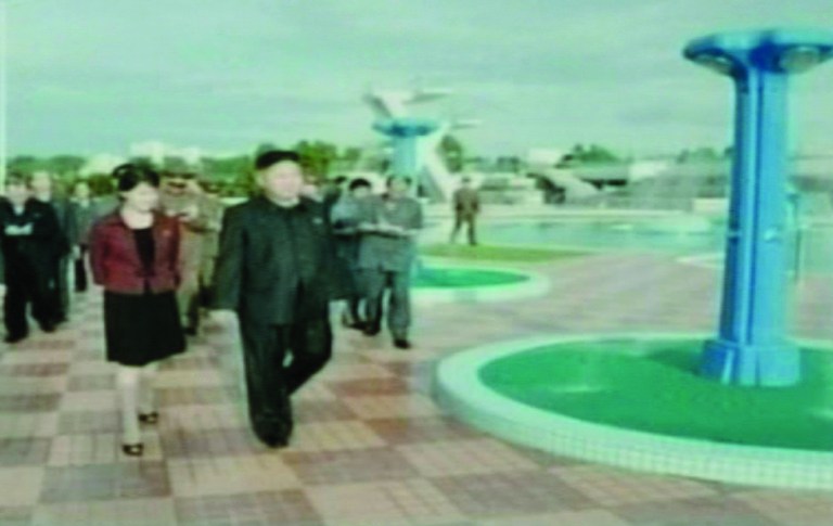 North Korean media on Wednesday July 25, 2012, identified the woman seen accompanying North Korean leader Kim Jong-un, front right, in a recent series of public appearances as his wife, named in news reports as comrade Ri Sol-ju, front left. Kim and his wife are seen Tuesday July 24, 2012, together attending a ceremony to mark the completion of an amusement park facility built on Rungna islet in Pyongyang, North Korea. The North Korea TV anchor woman said Kim toured an amusement park with his 