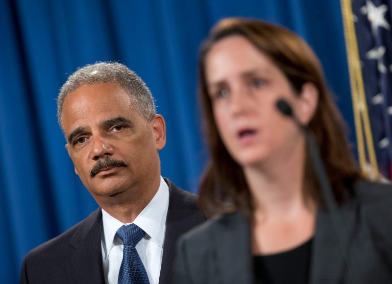 Attorney General Eric Holder listens at left during a news conference at the Justice Department in Washington, Thursday, Sept. 4, 2014, to announce the Justice Department's civil rights division will launch a broad civil rights investigation in the Ferguson, Mo., Police Department. At right is Acting Assistant Attorney General for Civil Rights Division Molly Moran. (AP Photo/Pablo Martinez Monsivais)