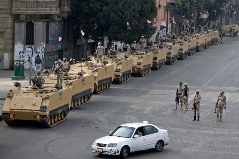 In this Friday, Aug. 16 file photo, Egyptian army soldiers take their positions on top and next to their armored vehicles to guard an entrance of Tahrir Square in Cairo. U.S. officials said today that the Obama administration is poised to slash hundreds of millions of dollars in military and economic assistance to Egypt. (AP Photo/Hassan Ammar, File)