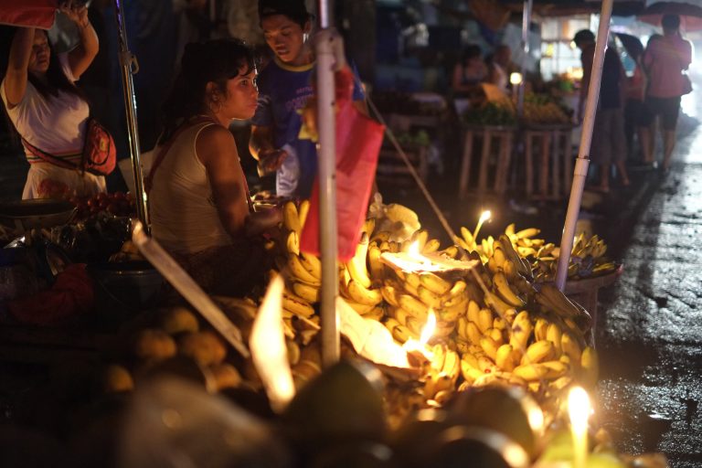 A Filipino vendor uses candles to illuminate bananas during a power outage a day after strong winds from Typhoon Rammasun damaged power supplies, in suburban Quezon city, north of Manila, Philippines, Thursday July 17, 2014. Parts of the capital and some provinces remain without power after Typhoon Rammasun barreled through northern Philippines leaving dozens of people dead and forcing more than half a million people to flee its lethal wind and rains, officials said Thursday. (AP Photo/Aaron Favila)