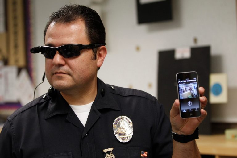 This Jan. 15, 2014 file photo shows Los Angeles Police Sgt. Daniel Gomez demonstrating a video feed from his camera into his cellphone as on-body cameras are demonstrated for the media in Los Angeles. Thousands of police agencies have equipped officers with cameras to wear with their uniforms, but they've frequently lagged in setting policies on how they're used, potentially putting privacy at risk and increasing their liability.(AP Photo/Damian Dovarganes)