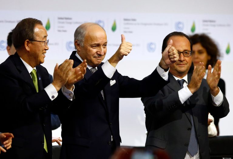 French foreign minister and President of the COP21 Laurent Fabius, center, with United Nations Secretary General Ban Ki-moon, left, and French President Francois Hollande at the COP21 conference. Environmental activists are criticizing the report for its nonbinding nature. (AP Photo/Francois Mori)