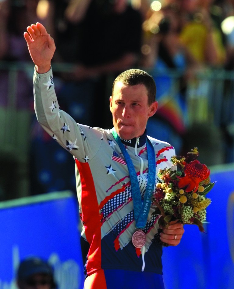 FILE - In a Sept. 30, 2000 file photo, U.S. cyclist Lance Armstrong waves after receiving the bronze medal in the men's individual time trials at the 2000 Summer Olympics cycling road course in Sydney, Australia. Officials familiar with the decision tell The Associated Press the IOC has stripped Armstrong of his bronze medal from the 2000 Sydney Olympics because of his involvement in doping. Two officials say the IOC sent a letter to Armstrong on Wednesday night, Jan. 16, 2013, asking him to return the medal. (AP Photo/Ricardo Mazalan, File)