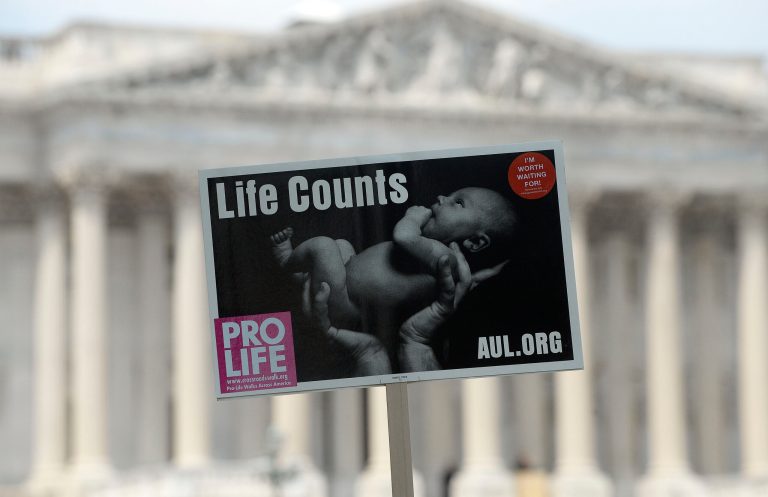 Anti-abortion activist sign is held aloft during a rally opposing federal funding for Planned Parenthood in front of the U.S. Capitol on July 28, 2015 in Washington, DC. (Photo by Olivier Douliery/Getty Images)