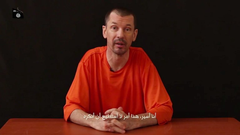 In this still image taken from an undated video published on the Internet by Al-Furqan, the media arm of the Islamic State group militants, captive British journalist John Cantlie speaks into the camera on the first of what he says will be a series of lecture-like 