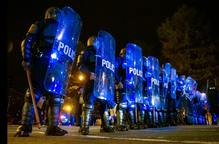 Atlanta Police in riot gear form a line on Williams Streets as protesters make their way down it in Atlanta, Ga., Tuesday, Nov. 25, 2014, after a night of protests over a grand jury's decision not to indict police officer Darren Wilson in the fatal shooting of Michael Brown in Ferguson, Mo., a case that has inflamed racial tensions in the U.S. (AP Photo/John Amis)