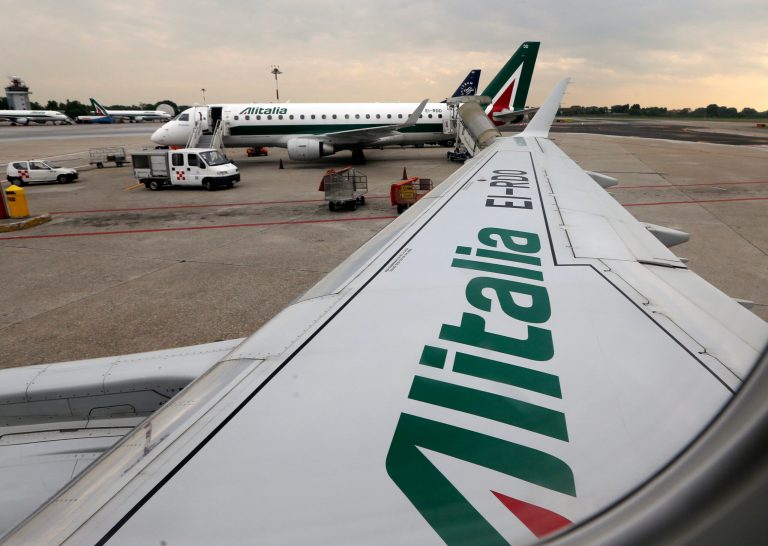 FILE- In this Wednesday, May 7, 2014, file photo, Alitalia planes wait on the tarmac prior to take off from the Linate airport, in Milan, Italy. Fast-growing Gulf carrier Etihad Airways says it and Alitalia have reached a deal in principle for the United Arab Emirates-based airline to buy a 49 percent stake in the struggling Italian airline. (AP Photo/Luca Bruno, File)