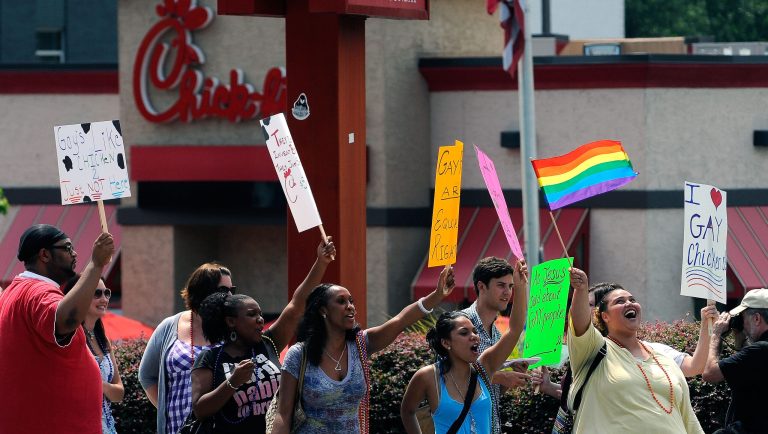 Gay rights groups and others protest and hold a "kiss-in" outside the Decatur, Ga., Chick-fil-A restaurant Friday, Aug. 3, 2012 as a public response to a company official who was quoted as supporting the traditional family unit. About two dozen protesters gathered on the busy corner to voice their views.  