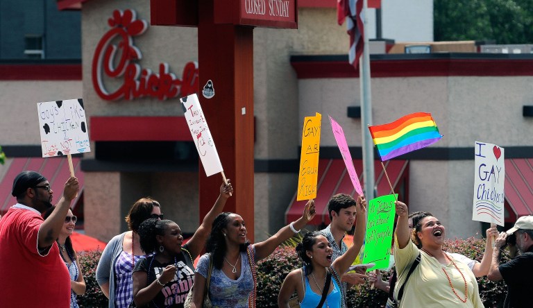 Gay rights groups and others protest and hold a "kiss-in" outside the Decatur, Ga., Chick-fil-A restaurant Friday, Aug. 3, 2012 as a public response to a company official who was quoted as supporting the traditional family unit. About two dozen protesters gathered on the busy corner to voice their views.   