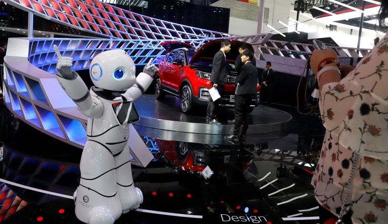 In this April 26, 2018, photo, a robot entertains visitors at the booth of a Chinese automaker during the China Auto 2018 show in Beijing, China. Under President Xi Jinping, a program known as "Made in China 2025" aims to make China a tech superpower by advancing development of industries that in addition to semiconductors includes artificial intelligence, pharmaceuticals and electric vehicles.
