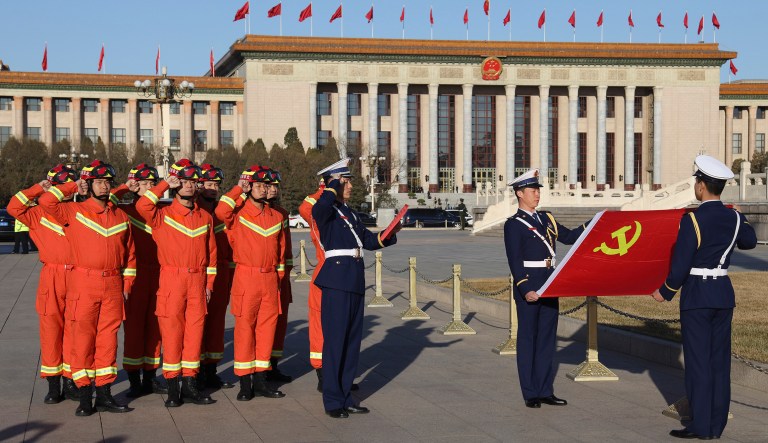 Chinese firefighters take an oath of loyalty near the Chinese Communist Party flag near the Great Hall of the People during a plenary session of the National People's Congress held in Beijing, China, Tuesday, March 12, 2019.