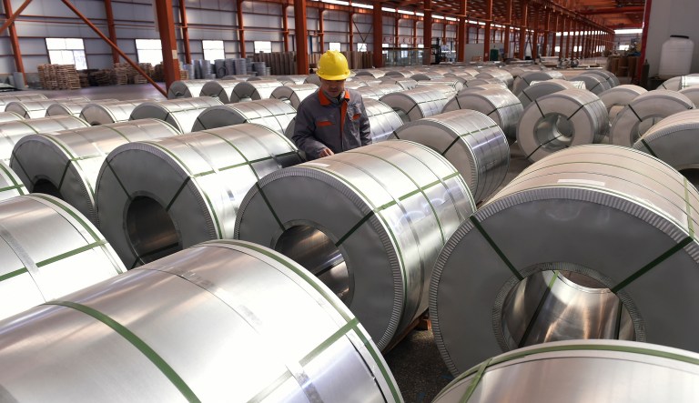 A worker checks on rolls of aluminium at a factory in Zouping county in east China's Shandong province, Saturday, April 7, 2018.  Unwilling to yield, U.S. President Donald Trump and China's government escalated their trade clash Friday, with Beijing vowing to "counterattack with great strength" if Trump follows through on threats to impose tariffs on an additional $100 billion in Chinese goods.
