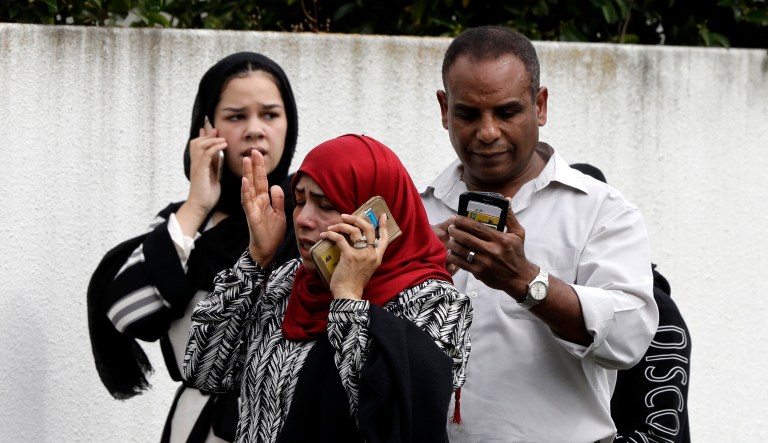 People wait outside a mosque in central Christchurch, New Zealand, Friday, March 15, 2019. Many people were killed in a mass shooting at a mosque, a witness said.