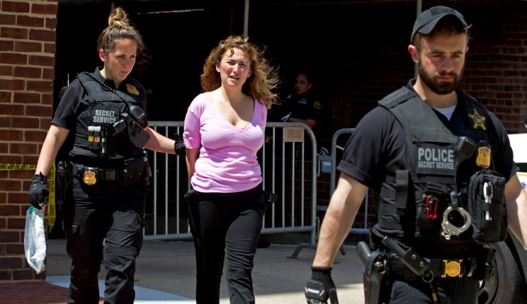 A pro Nicolas Maduro supporter Code Pink member Ariel Gold is arrested after attempting to throw food and supplies into the Venezuelan Embassy in Washington, Thursday, May 2, 2019. Pro interim government opposition leader Juan Guaido supporters have blocked the entrances to the embassy, cutting off supplies to pro Nicolas Maduro supporters occupying the building. 