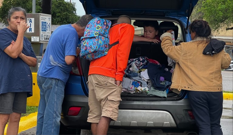 A family of immigrants stands outside a bus station in Brownsville, Texas, where hundreds of migrants flow through each day after receiving their DHS processing paperwork. 