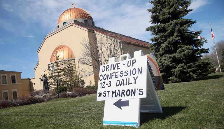 A sign outside St. Maron's Maronite Catholic Church in northeast Minneapolis posts the way to the drive-up confession site Monday, March 30, 2020 as efforts continue to slow down the coronavirus in the state. The new coronavirus causes mild or moderate symptoms for most people, but for some, especially older adults and people with existing health problems, it can cause more severe illness or death. 