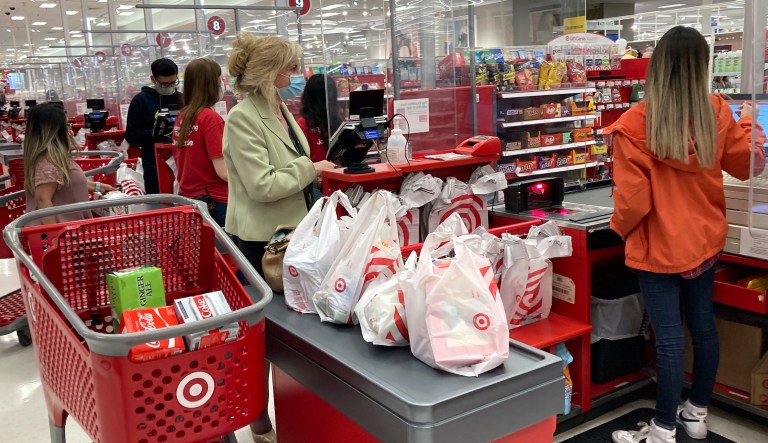 A customer wears a mask as she waits to get a receipt at a register in Target store in Vernon Hills, Ill., Sunday, May 23, 2021.  Consumer spending was flat in May while incomes dropped for a second month as the impact of the governmentâs individual impact payments waned.