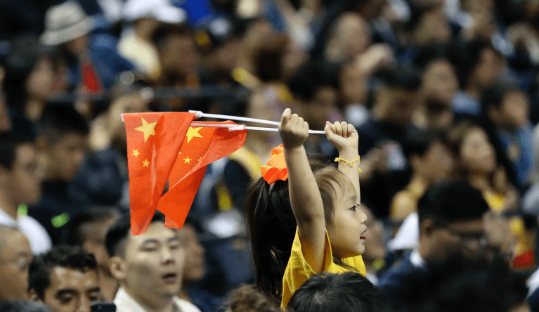A child holds up two Chinese national flags as she watches a preseason NBA basketball game between the Brooklyn Nets and Los Angeles Lakers at the Mercedes Benz Arena in Shanghai, China, Thursday, Oct. 10, 2019.