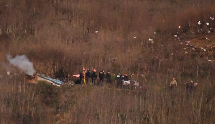 A body is moved from the scene of a helicopter crash that killed former NBA basketball player Kobe Bryant in Calabasas, Calif., Sunday, Jan. 26, 2020.
