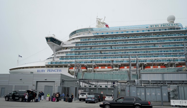 People stand on a pier outside the Ruby Princess cruise ship and wait to be picked up in San Francisco, Thursday, Jan. 6, 2021.