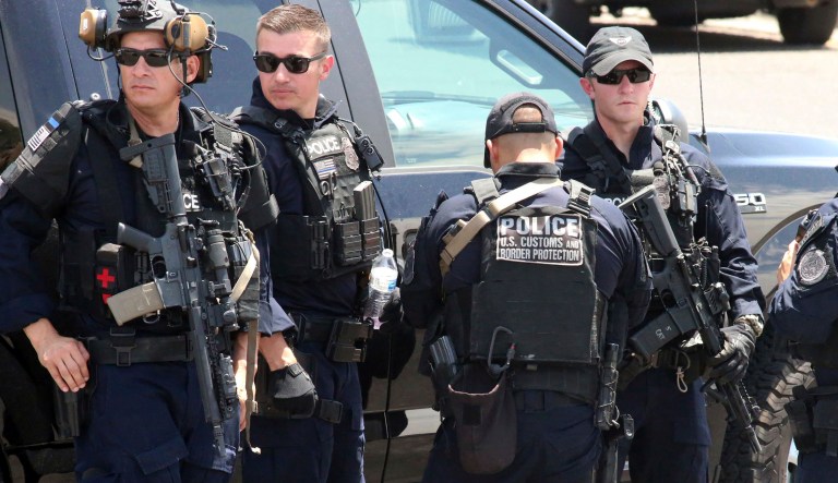 U.S. Customs and Border Protection officers gather near the scene of a shooting at a shopping mall in El Paso, Texas, on Saturday, Aug. 3, 2019.