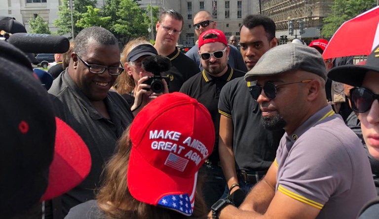 A person wearing a "Make America Great Again" hat meets with people coming from an antifa rally in D.C.