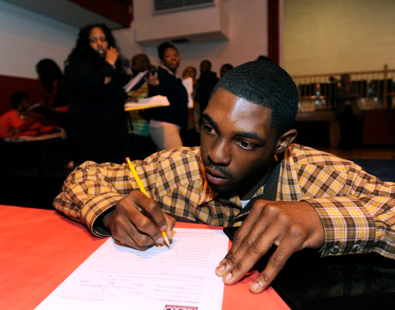 In this April 23, 2014 photo, Davon Tremble, of Detroit, fills out an application at a job fair at the Matrix Center in Detroit. The Labor Department reports the number of people who applied for unemployment benefits last week on Thursday, May 15, 2014. (AP Photo/The Detroit News, David Coates)