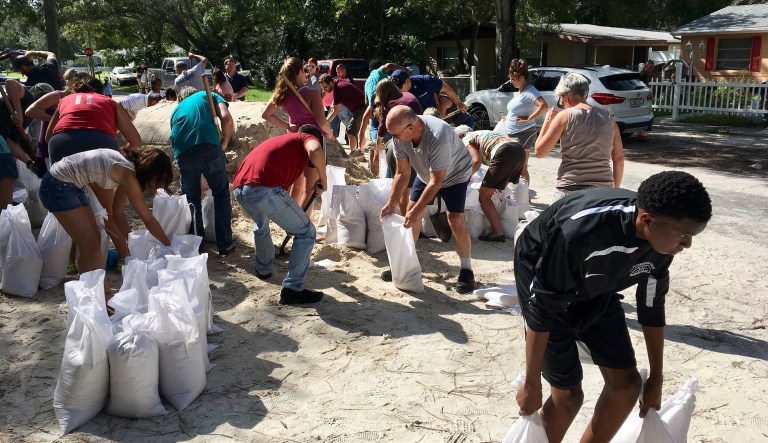 Florida residents carry sandbags in preparation for Hurricane Irma. President Trump said his federal officials are in Florida preparing for the hurricane. (Lara Cerri/Tampa Bay Times via AP)