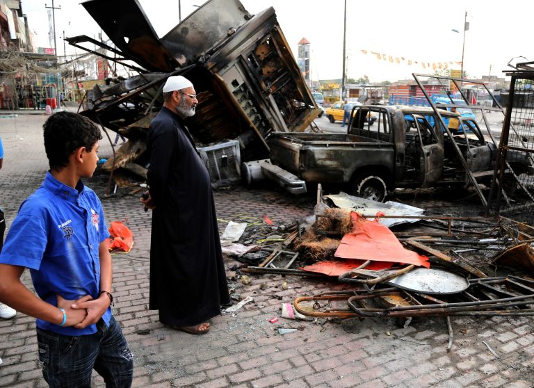 Iraqi civilians inspect debris left in the aftermath of a car bombing on a commercial street in Baghdad's eastern neighborhood of Sadr City, Iraq, Friday, April 11, 2014. Two car bombs exploded in Shiite neighborhoods of Iraq's capital Thursday night, killing and wounding scores of people, as violence roars on before a crucial election later this month, authorities said. Last year, Iraq weathered its deadliest bout of violence since it pulled back from the brink of civil war in 2008. (AP Photo/Karim Kadim)
