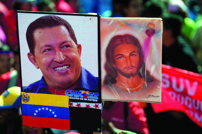 A picture of Venezuela's President Hugo Chavez is held up alongside an image of Jesus Christ at a rally by Chavez supporters in Caracas, Venezuela, Thursday, Jan. 10, 2013. The government organized the unusual show of support for the cancer-stricken leader on the streets outside Miraflores Palace on what was supposed to be his inauguration day. The Supreme Court on Wednesday backed the plan to put off the inauguration indefinitely, saying the president could be sworn in before the court at a later date. (AP Photo/Ariana Cubillos)