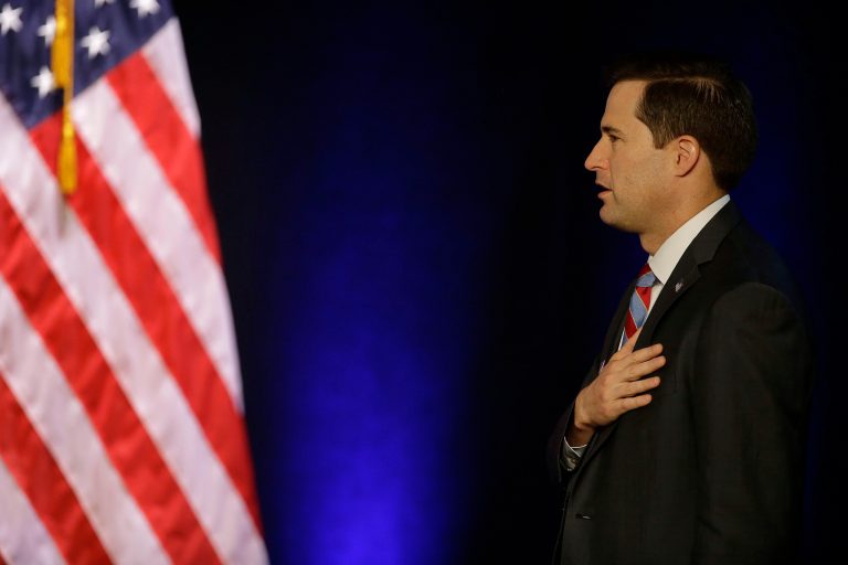 Seth Moulton, Democratic candidate for congress from Massachusetts, holds his hand over his heart during the singing of the national anthem before First Lady Michelle Obama attends a campaign event for Massachusetts Democratic gubernatorial candidate Martha Coakley during a Coakley for Governor campaign rally at the Strand Theatre Oct. 3, 2014 in Boston. (AP Photo/Stephan Savoia)