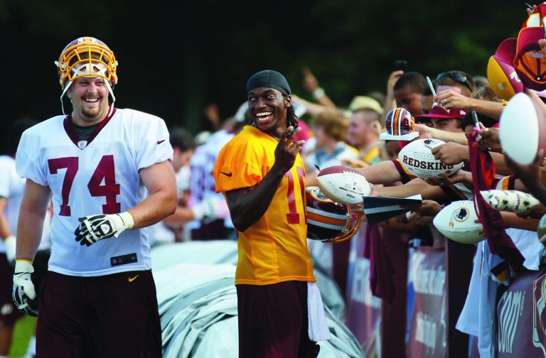 Washington Redskins offensive tackle Tyler Polumbus (74) and Washington Redskins quarterback Robert Griffin III (10) laugh as they visit with fans and sign autographs during an NFL football training camp at Redskins Park, Friday, July 27, 2012, in Ashburn, Va. (AP Photo/Carolyn Kaster)