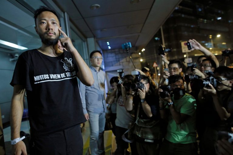 Ken Tsang, a member of a local pro-democracy political party shows his wound outside a police station after a clash between protesters and police in an occupied area near government headquarters in Hong Kong Wednesday, Oct. 15, 2014. Hundreds of Hong Kong police officers drove protesters from an underpass in the dead of night Wednesday, the worst violence since the street demonstrations for greater democracy began more than two weeks ago. Local television channel TVB showed footage of around six plainclothes police officers taking a man around the side of a building, pushing him to the ground and kicking him. Local legislators and activists identified the protester as Ken Tsang, a member of a local pro-democracy political party. (AP Photo/Vincent Yu)