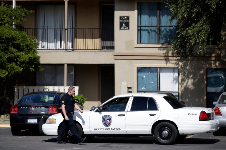 Law enforcement vehicles are parked in front of building six of The Ivy Apartments complex, Wednesday, Oct. 1, 2014, in Dallas. The man diagnosed with having the Ebola virus was staying at the complex with family and is now hospitalized. Officials are monitoring 12 to 18 people who may have been exposed to the man. (AP Photo/Tony Gutierrez)